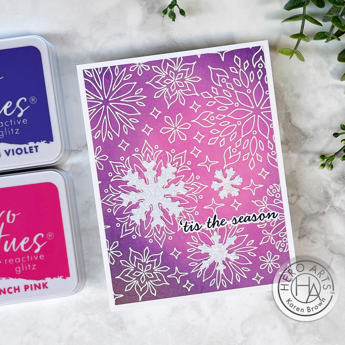 Snowflake Chirstmas Holiday card with heat embossed snowflakes and die cut snowflakes over a ink blended pink and purple background.