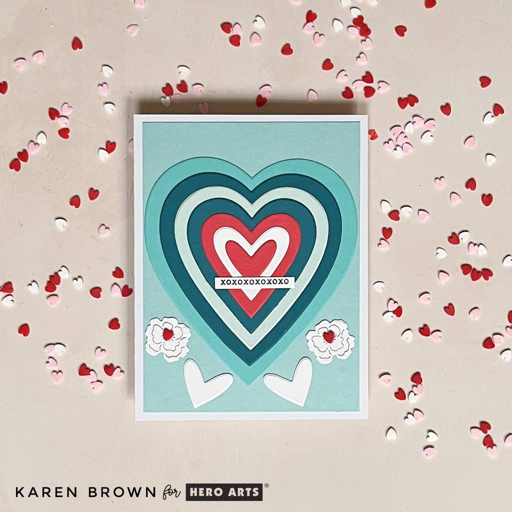 Stacked die cut hearts on a colorful teal and red handmade Valentine Card.
