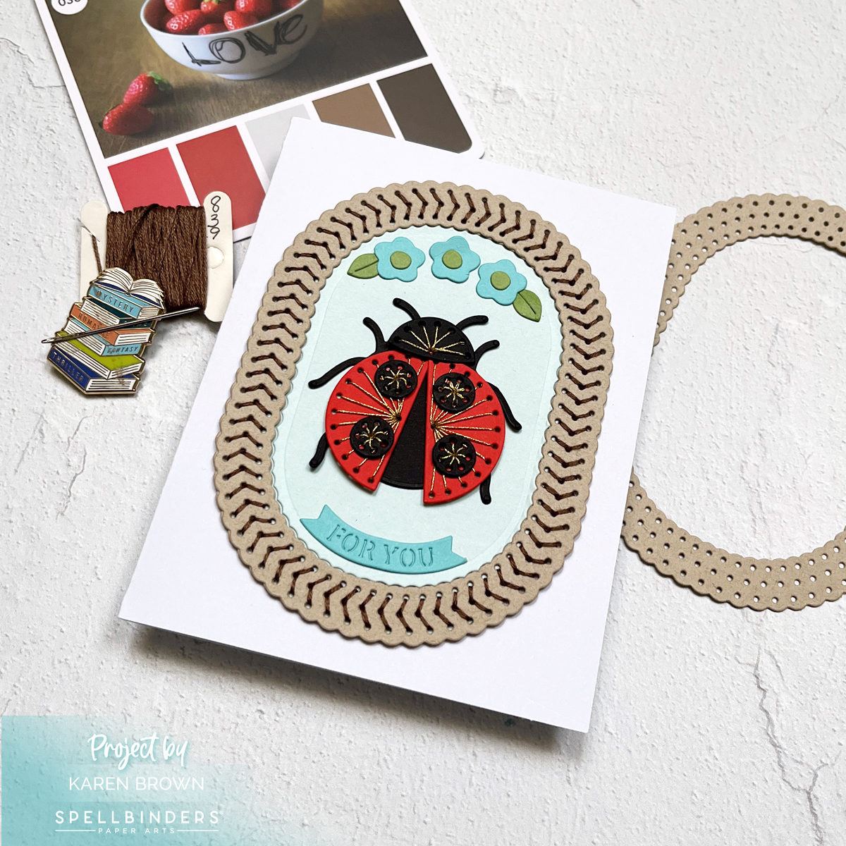 Delightful handmade greeting card with stitched ladybug and oval frame elements perfect for any occasion.  