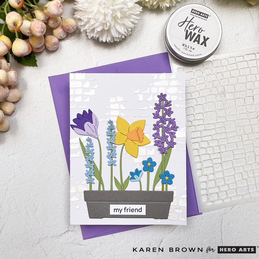 handmade die-cut planter box card featuring wisteria, daffodils, and blue blossoms on a stenciled cobblestone wall background.