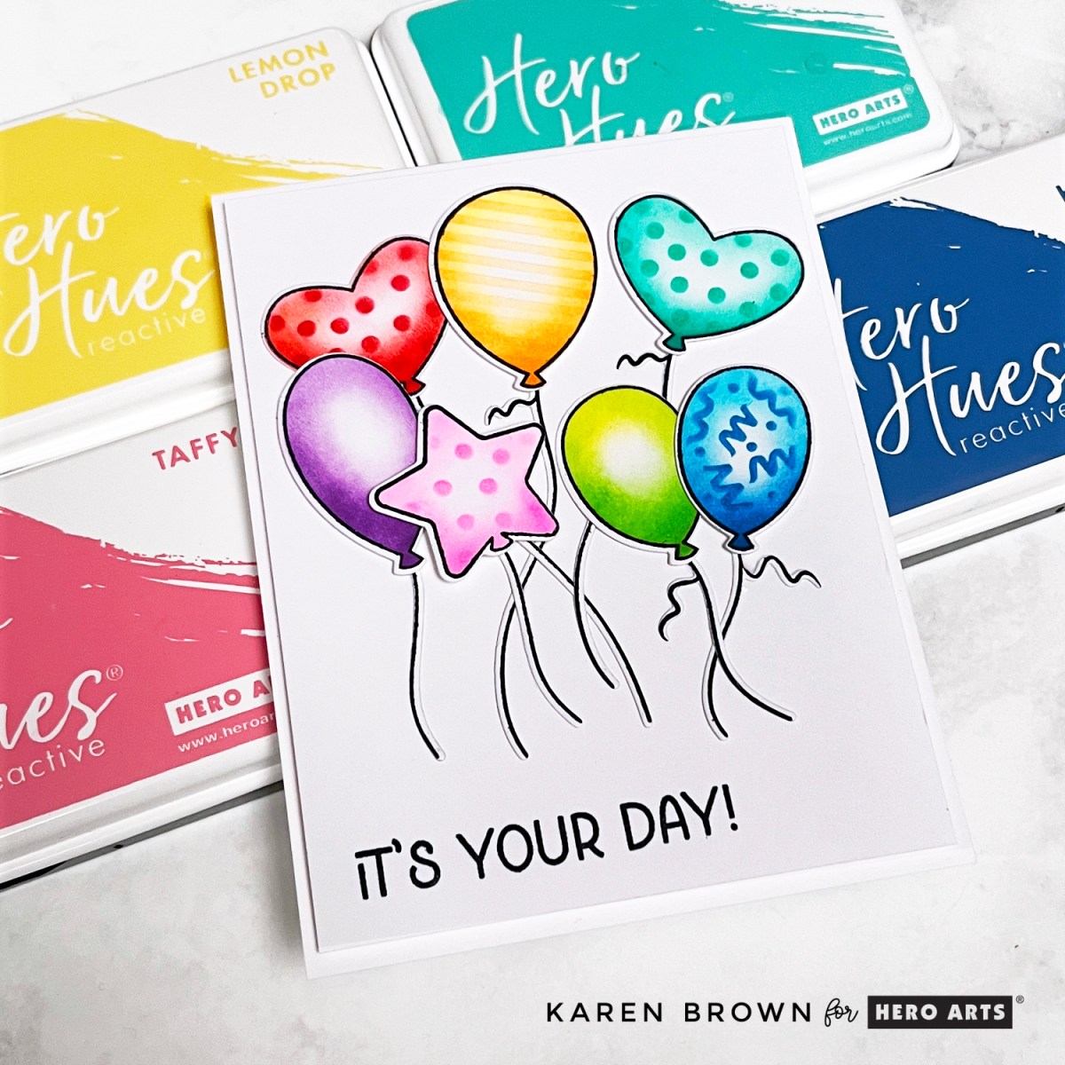 7 stamped, rainbow ink blended, stenciled and die cut dancing and floating balloons on a handmade card perfect for Birthdays, Graduation or any festive occasion.