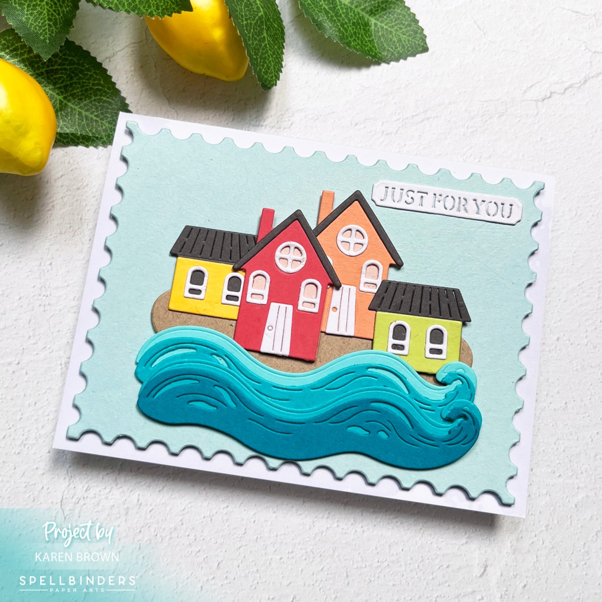 Spellbinders June 2025 Large Die of the Month card featuring a tiny village of rainbow colored cottages with rolling waves. 