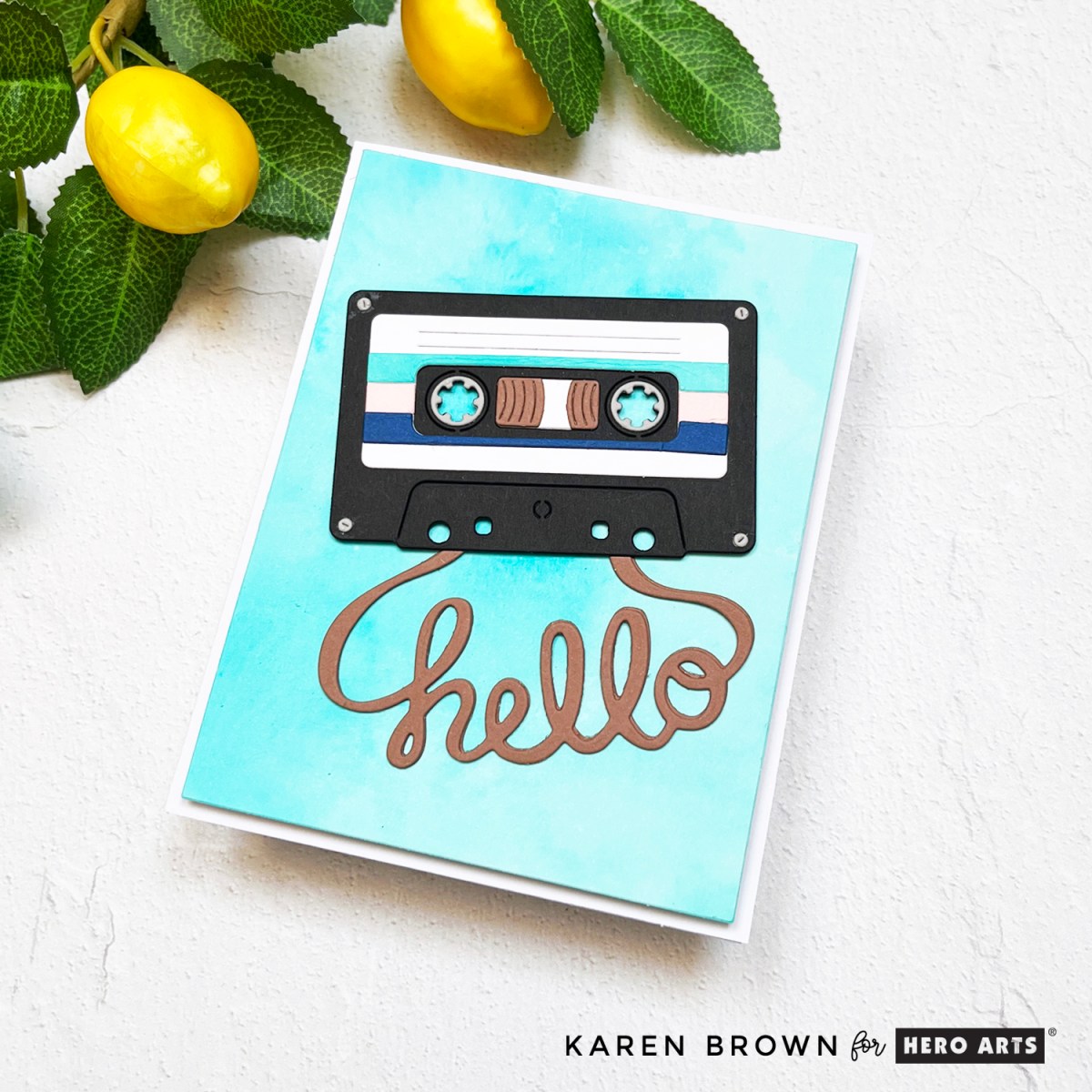 Summery aqua ink smoosh card background with a die cut retro cassette tape and scripty hello background.