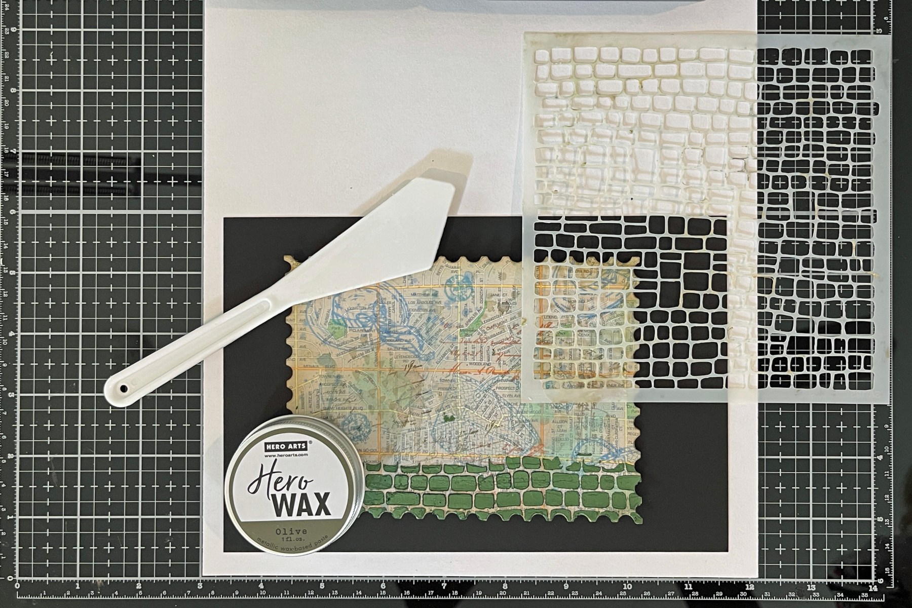 process photo showing olive Hero Wax applied through a Cobblestone stencil.