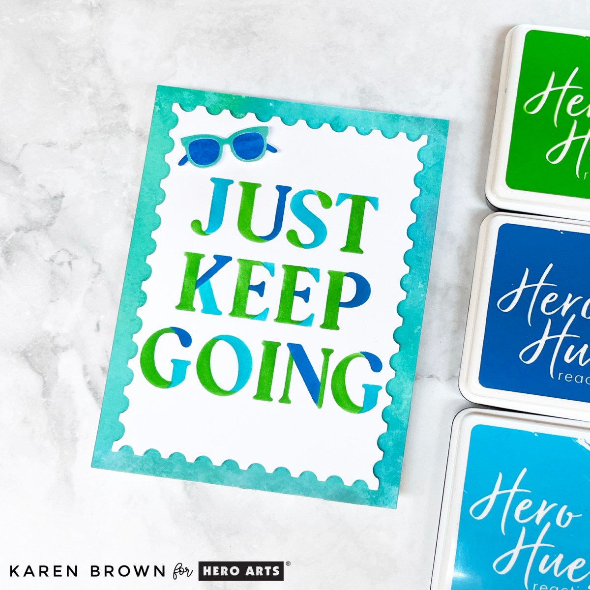 Handmade card with bold “Just Keep Going” encouraging sentiment in green, teal, and blue ink, layered over a watercolor-style ink smooshed background.