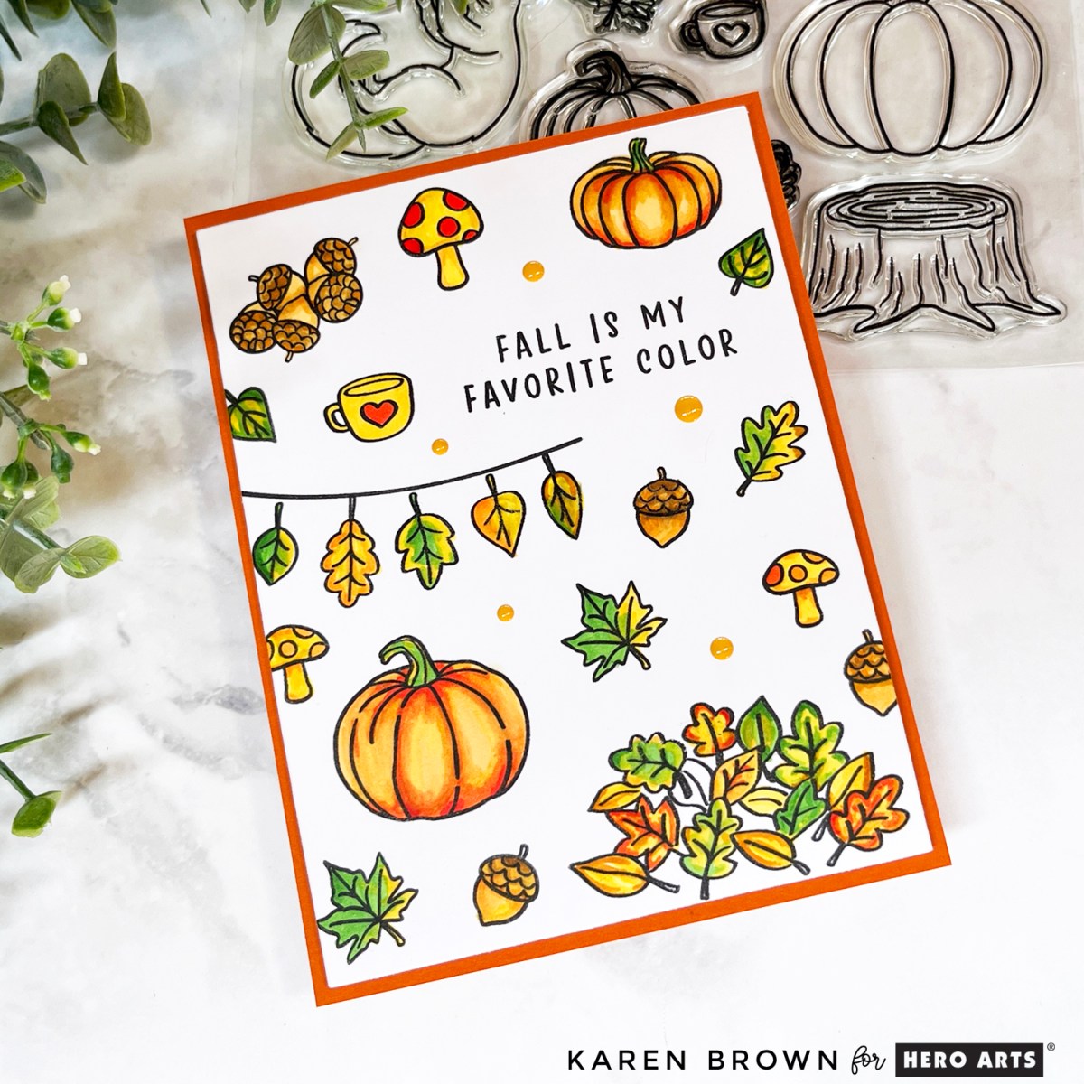One-layer fall card featuring stamped and colored pumpkins, mushrooms, acorns, and leaves with the sentiment “Fall is my Favorite Color” created with Hero Arts September 2025 Card Kit of the Month.  Embellished with enamel dots.