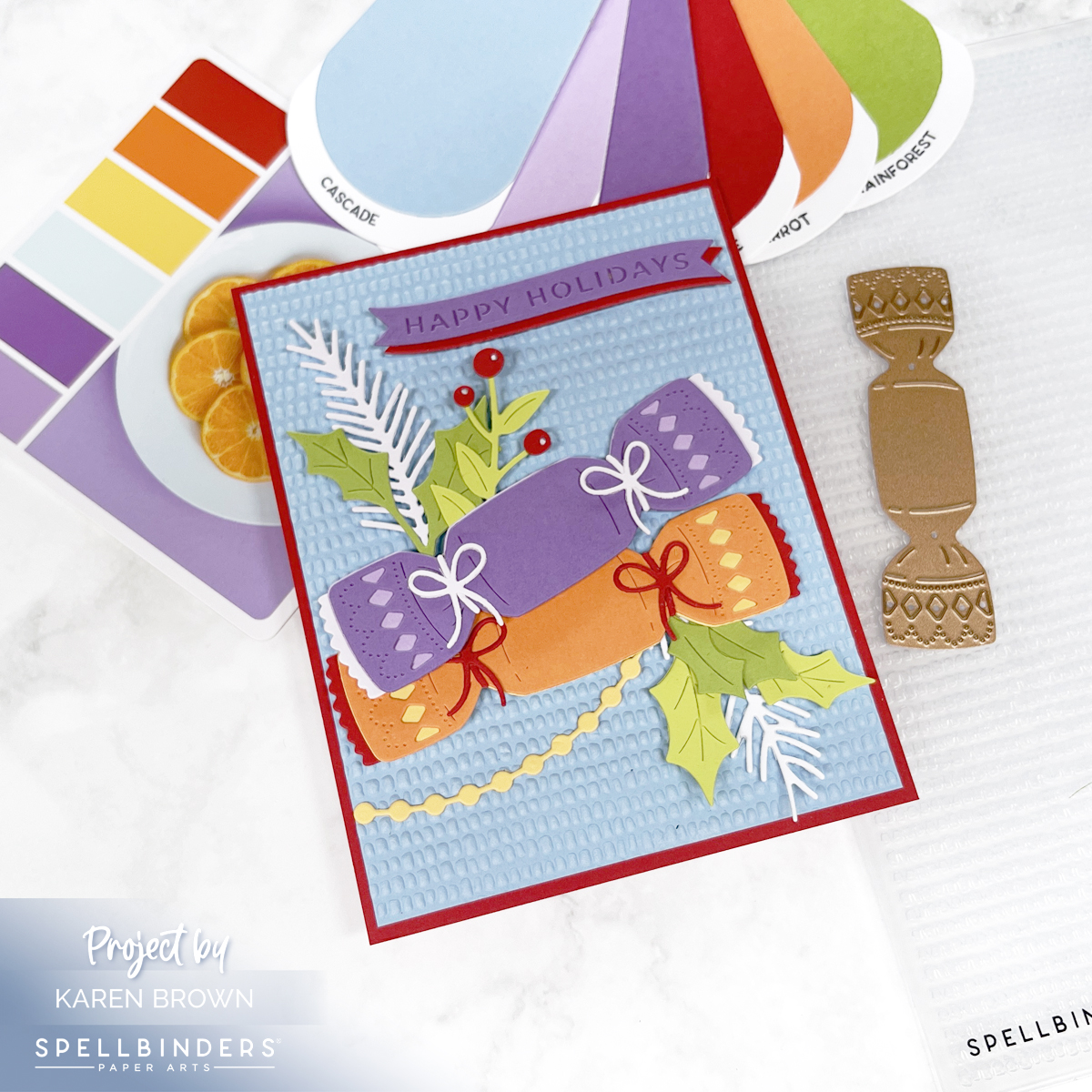 Handmade Christmas card featuring a colorful die cut Christmas cracker in shades of purple, orange, blue, and green. The background is embossed with a dimpled 3D pattern, and some die cuts are raised on foam for added dimension