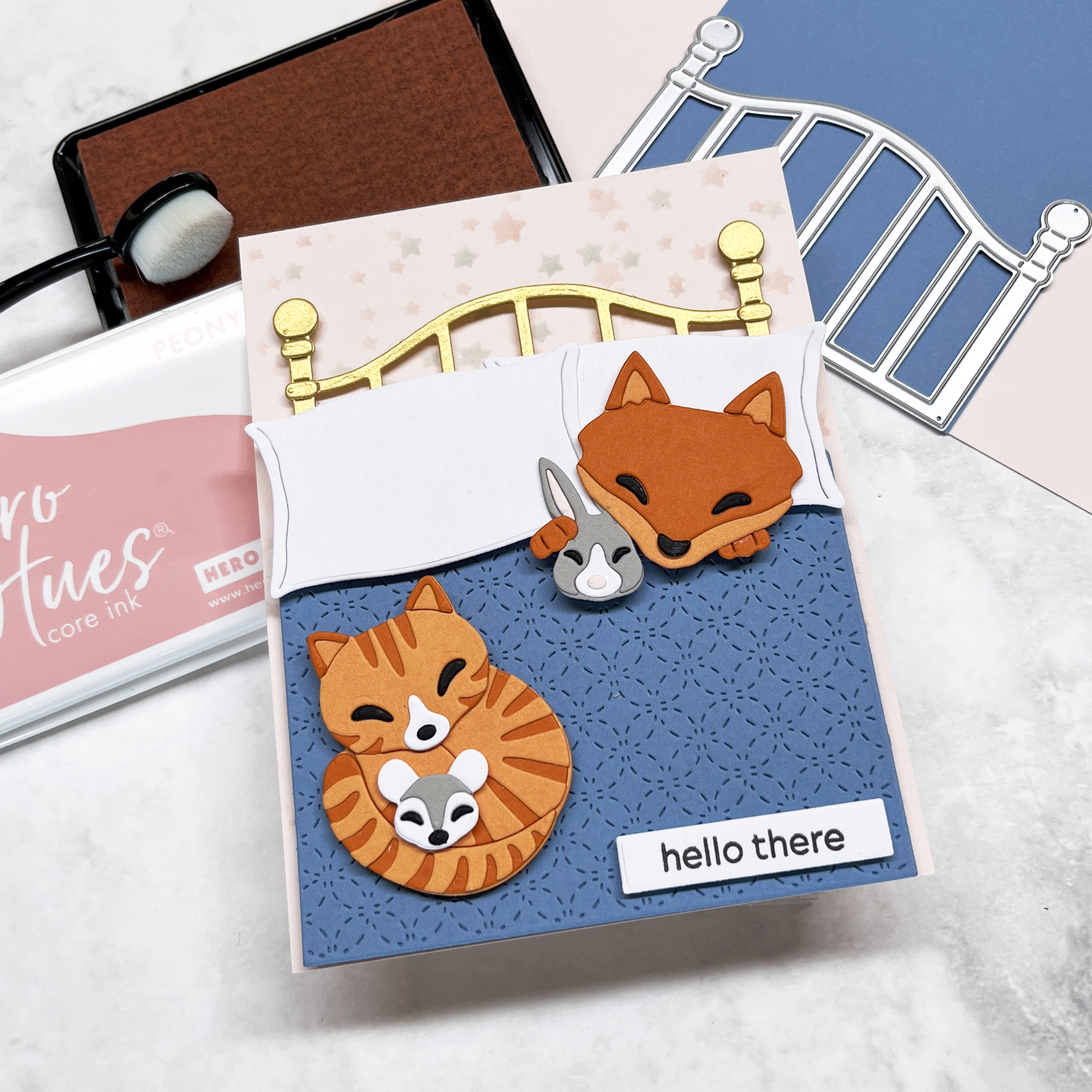 Die cut critter card of snuggly animals in bed.