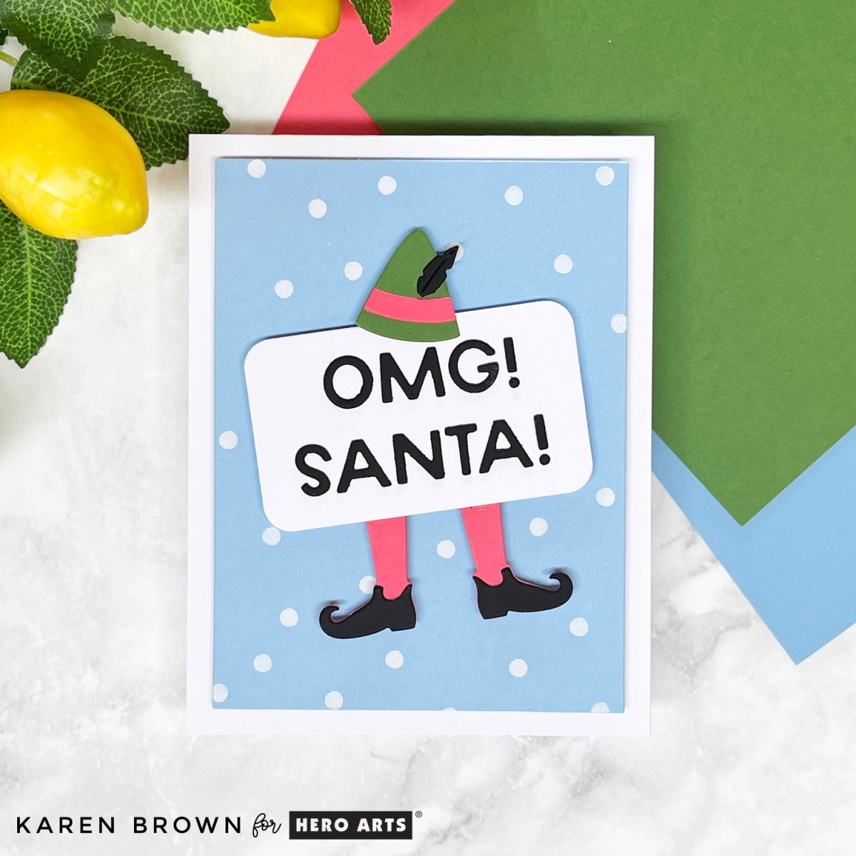 Adorable die-cut Christmas elf card on a hot-foiled background that simulates falling snow.  