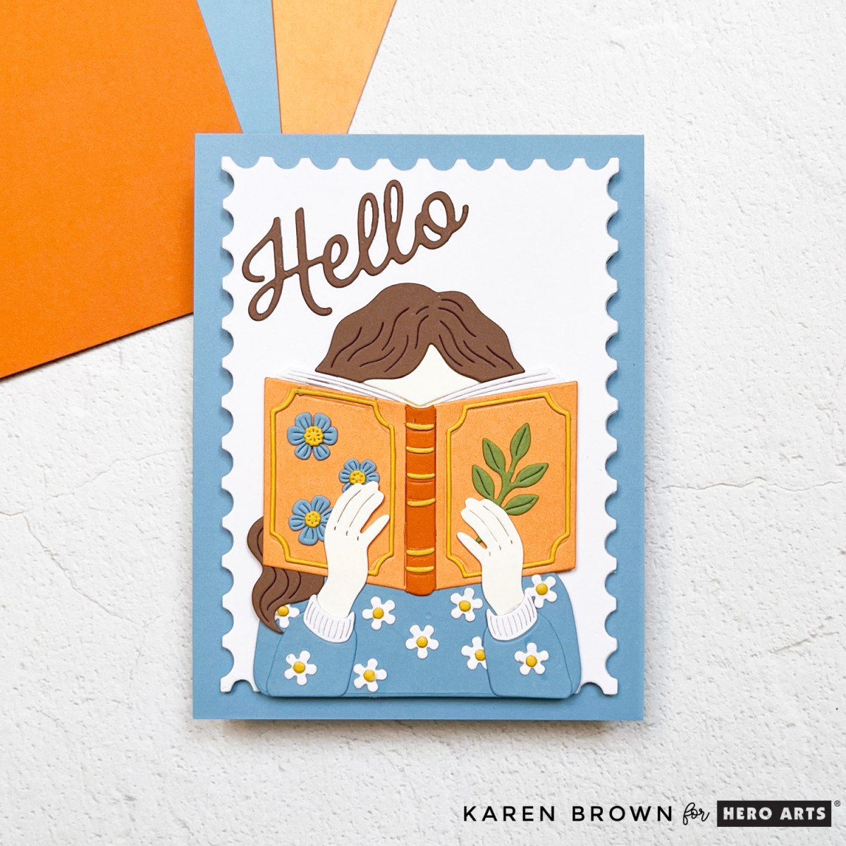 Handmade book theme scene card created with Hero Arts November 2025 Card Kit.  Colors are periwinkle blue, orange and brown.