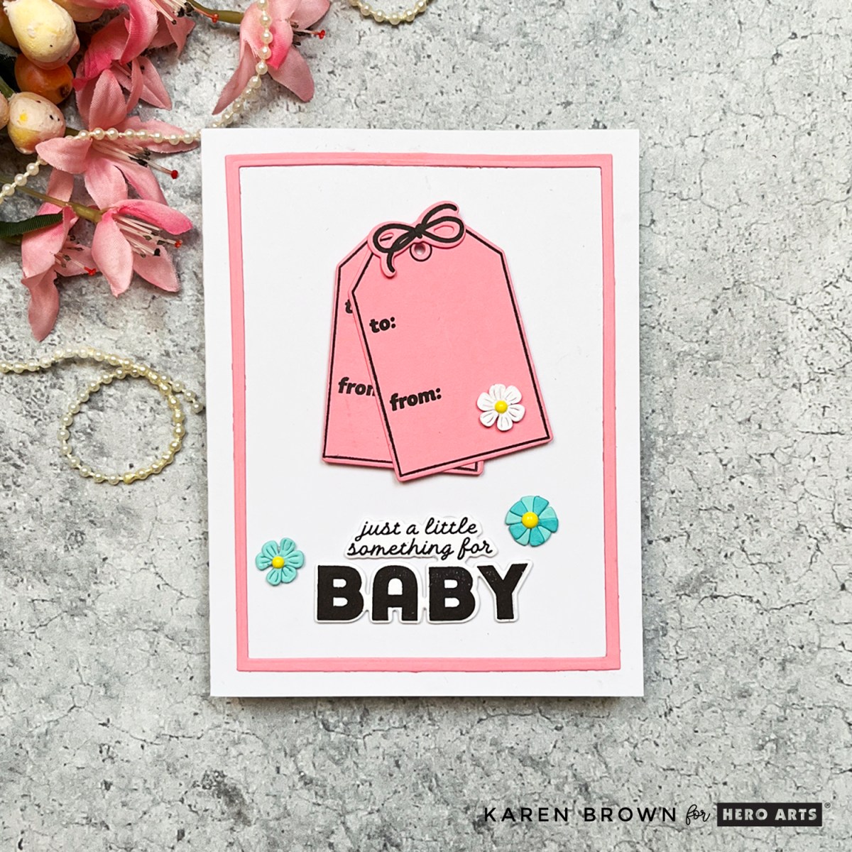 Photo of handmade Baby card with stamped tags with black sentiment reading “Just a little something for baby."