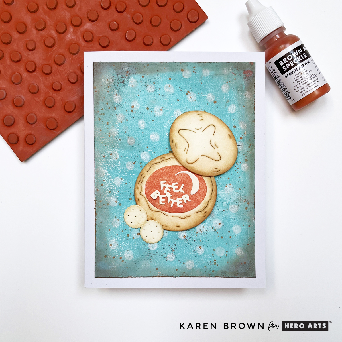Mixed media card featuring Gel Press print stamped with white Dotty pattern background stamp, distressed and ink-blended edges, brown speckles, and die-cut bread bowl with “Feel Better” sentiment.