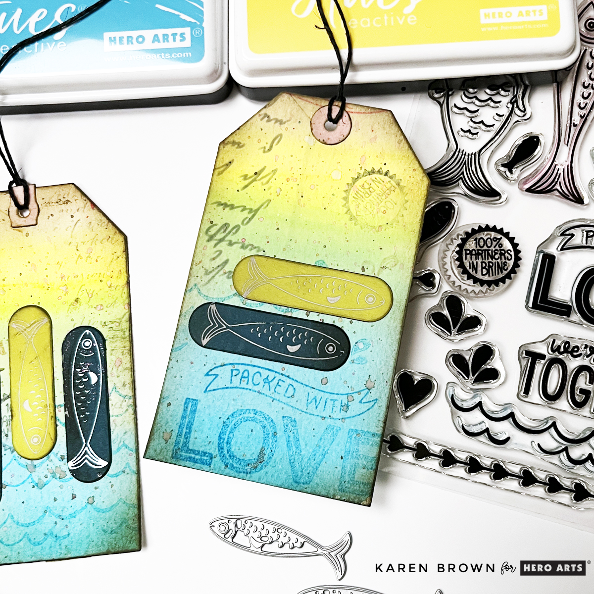 Watercolor background Mixed Media tag with script stenciling, second generation stamping and die cut fish.