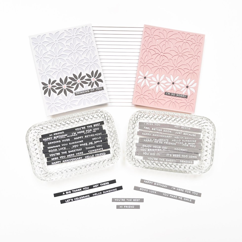 Photo showing die cut 2 batches of sentiment strips along with two cards.