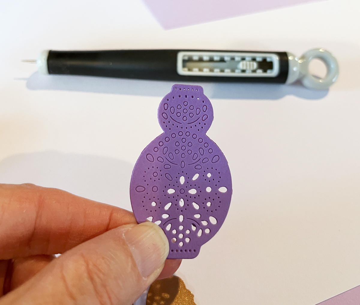 Process photo showing a pierced die-cut vase that will be used on a floral homemade card.