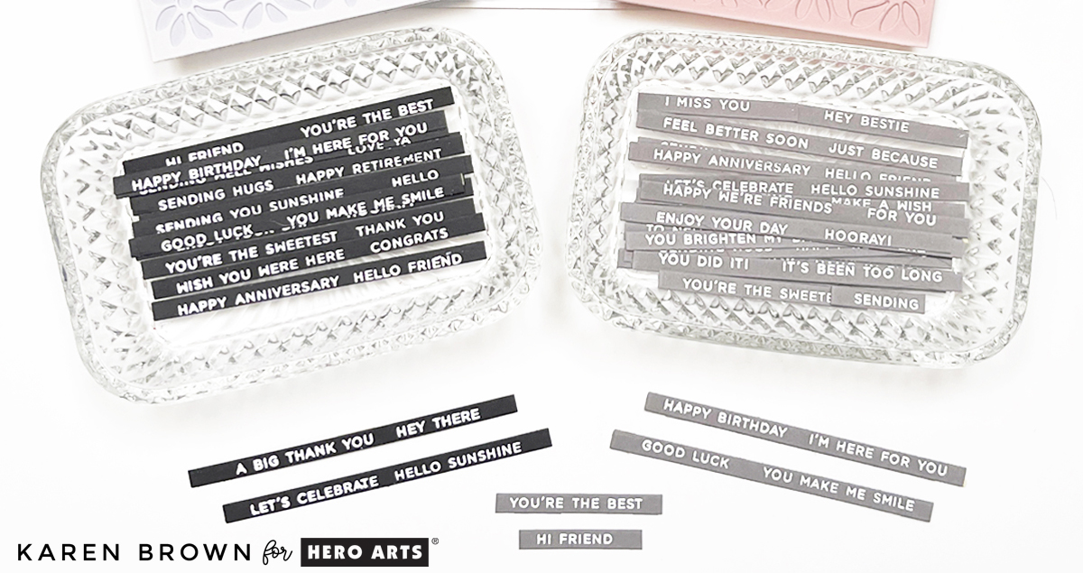 Two batches of heat embossed sentiment strip strips.  White on gray and black cardstock.