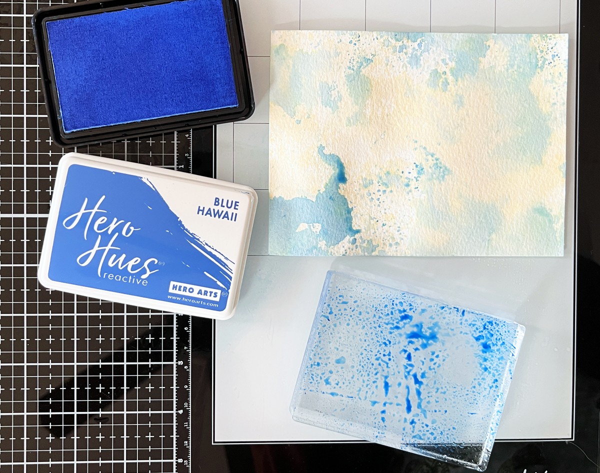 Process photo showing Ink Smoosh Acrylic block stamping variation with blue ink on watercolor paper.