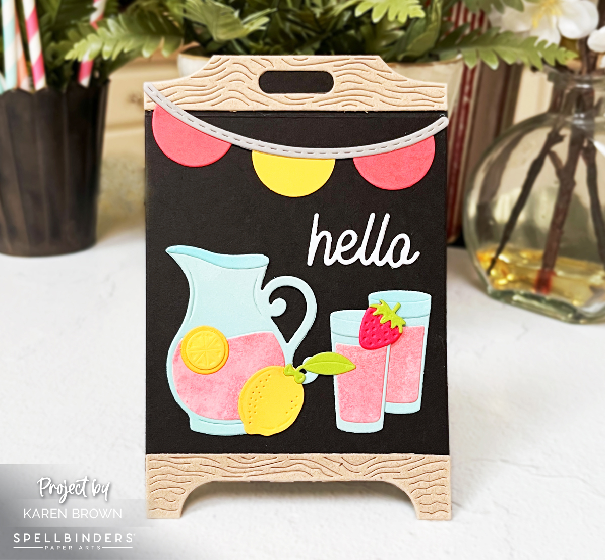 Lemonade stand easel card with pink lemonade pitcher, lemons, banner, and black chalkboard background.  Spellbinders S6-269