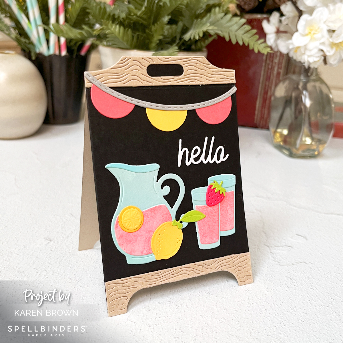 Angled side view of pink lemonade stand easel card standing upright for display