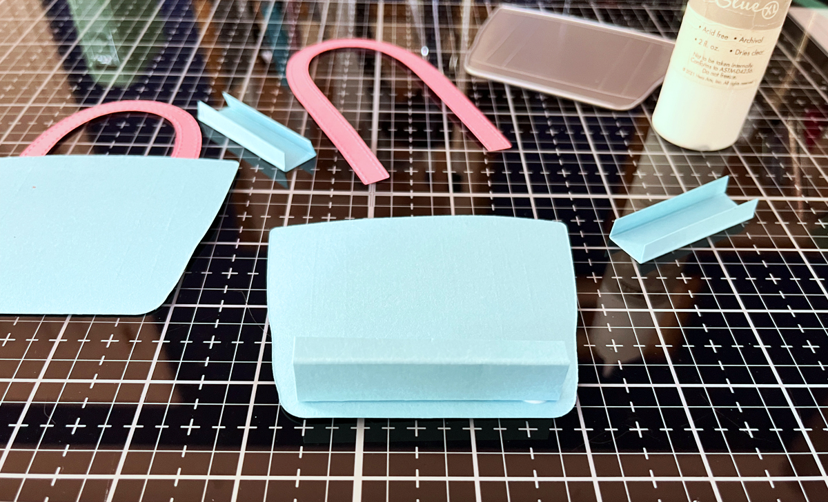 Craft desk showing tote die cuts, cardstock, and tools mid-project