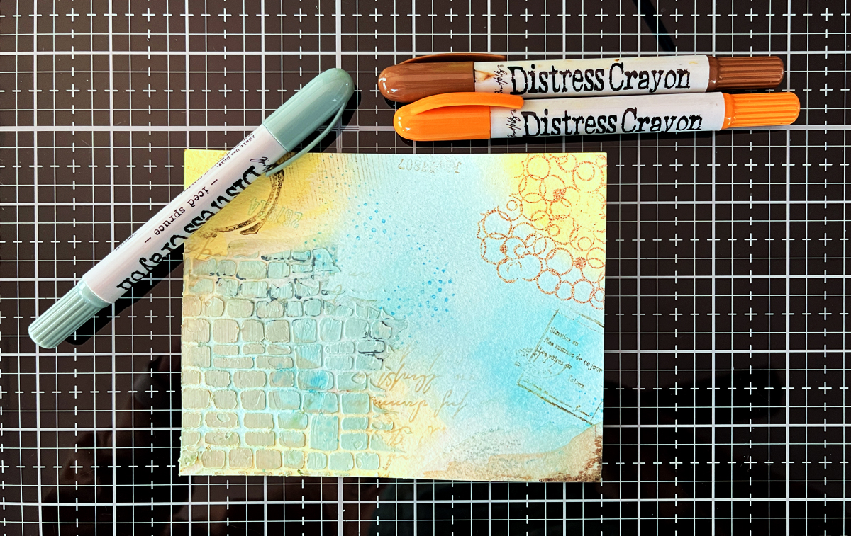 Distress crayons can add interest to mixed media card backgrounds.