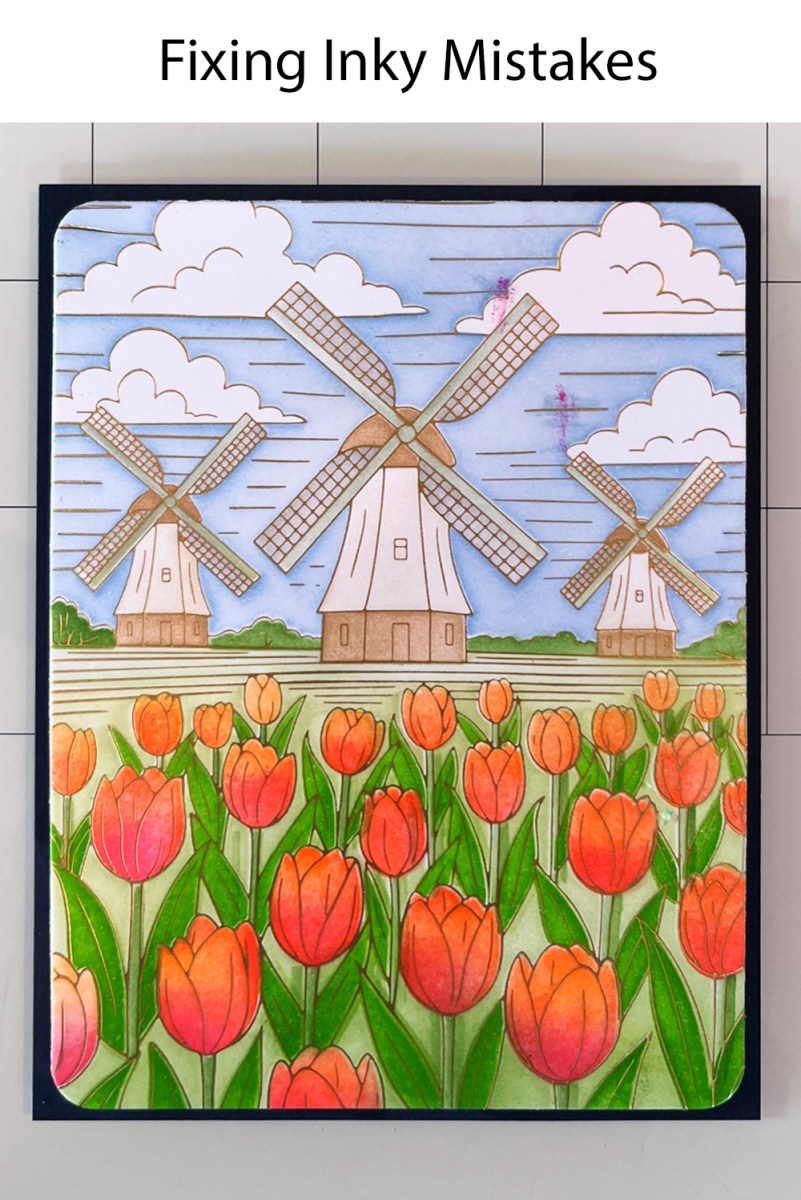 Fixing mistakes - unwanted ink spot on  a cardmaking project - how to repair. Process photo showing pink ink spots on blue sky before sentiment placement.