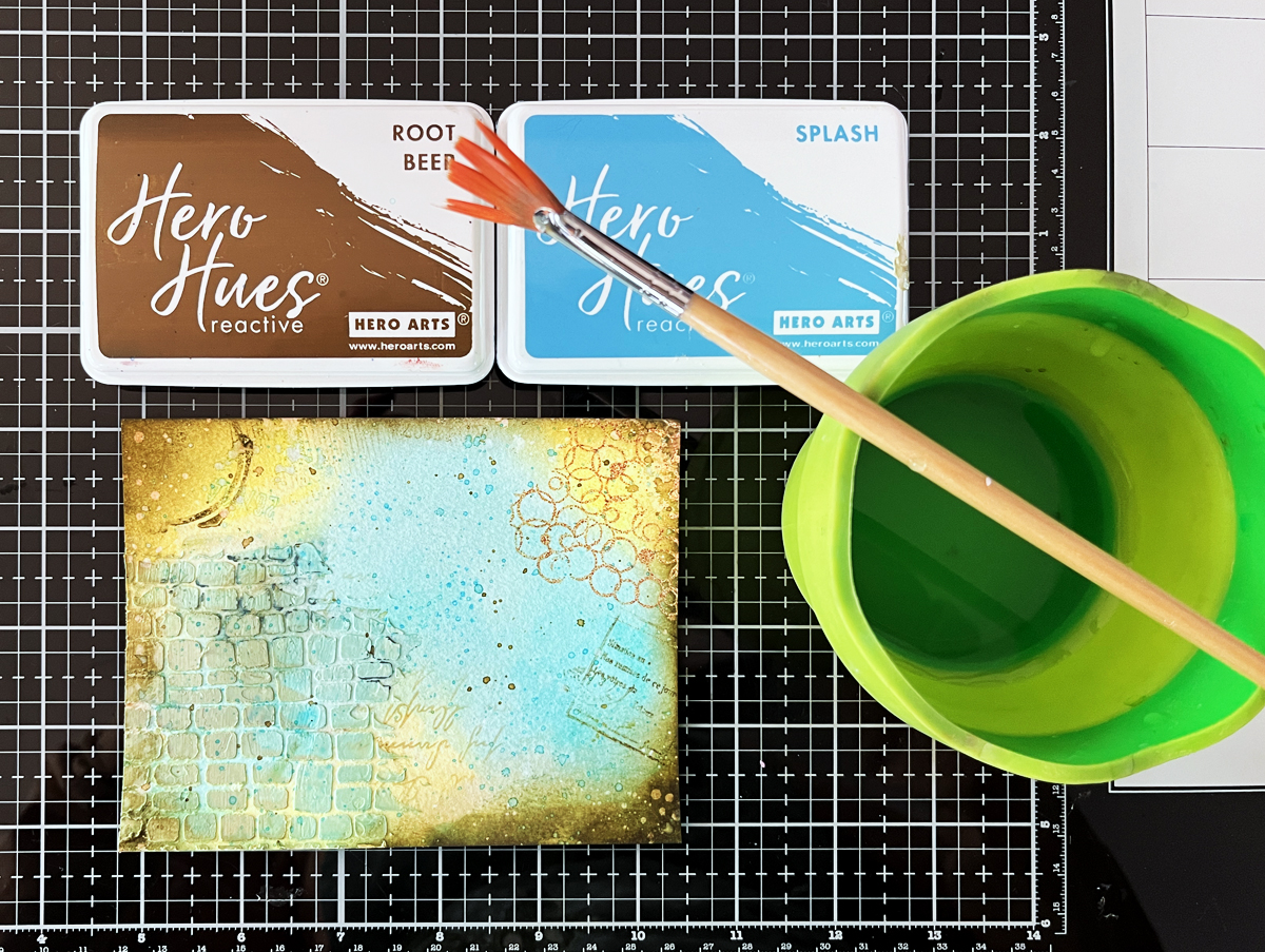 Adding splatters to mixed media intermediate level watercolor card background that has 7 different layering techniques.