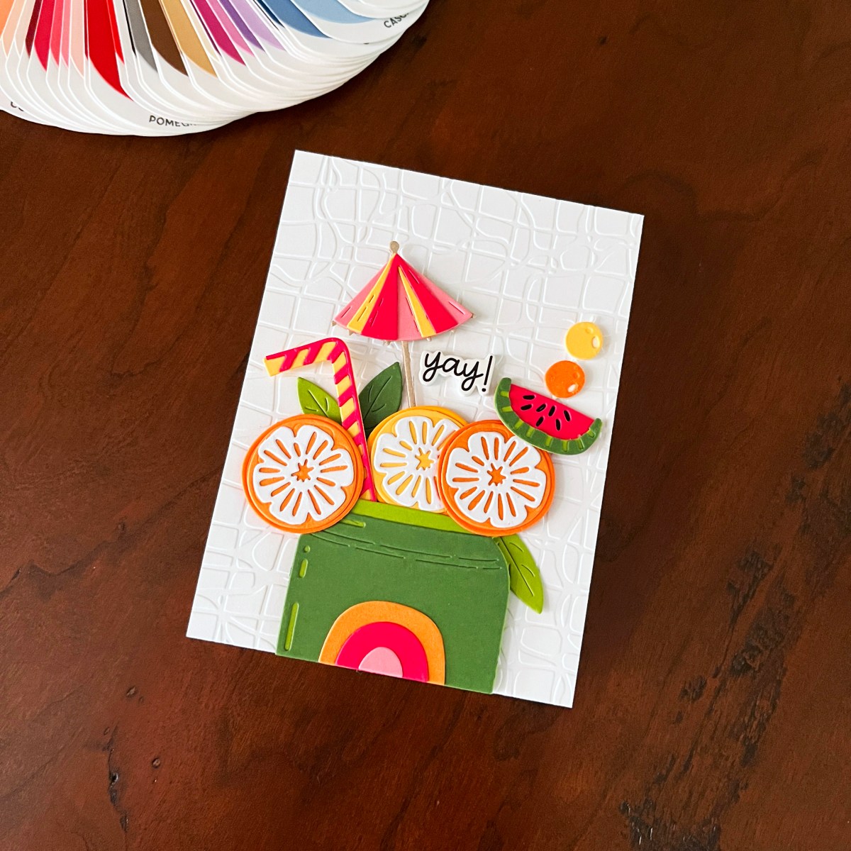 Bright summer die cut card featuring citrus slices, colorful drink elements, and embossed white background