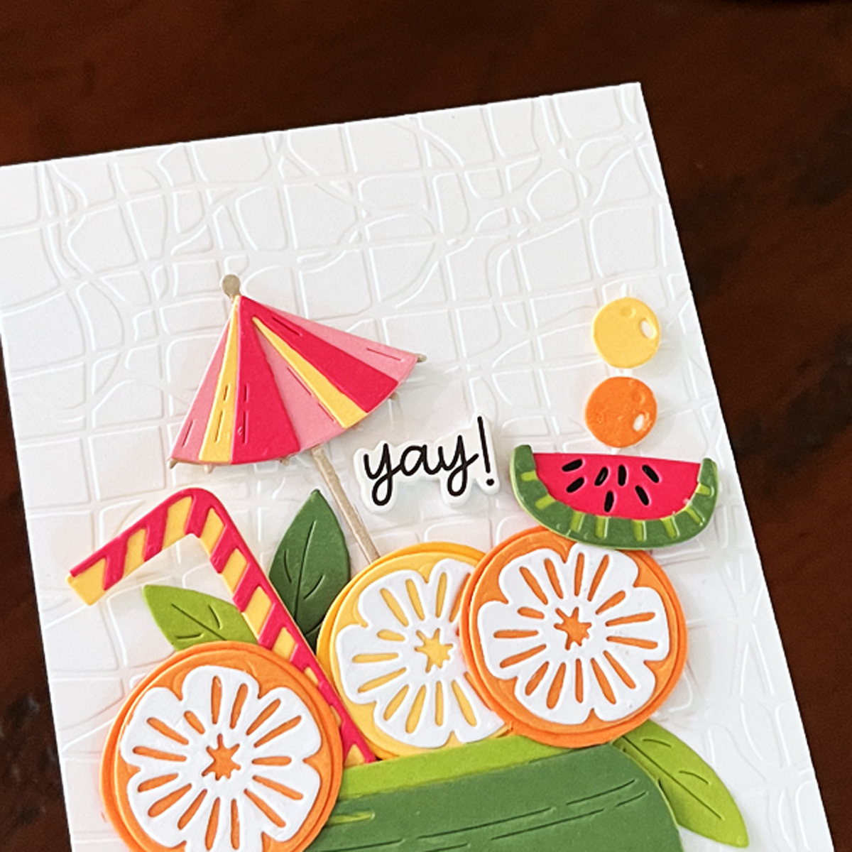 Die cut lemon and orange slices on a coloful card.