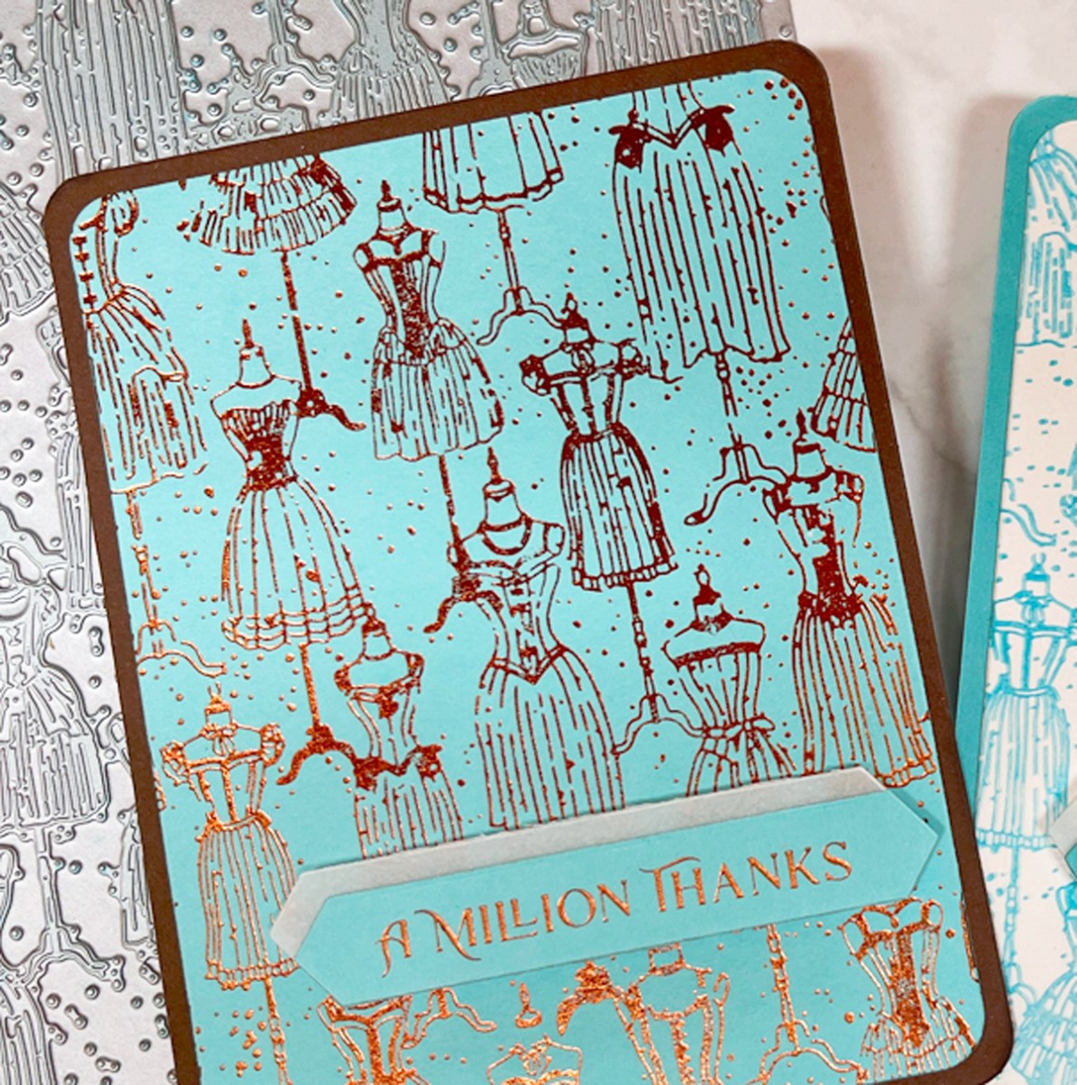 closeup photo of copper glimmer hot foiled dressmaker thank you card on aqua background