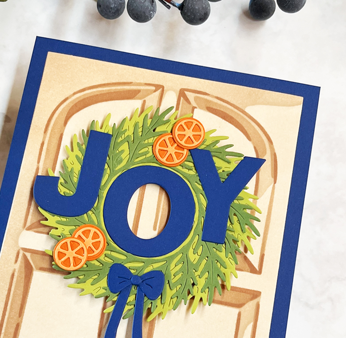 Close-up of my die cut winter wreath card with orange slices and Large die cut JOY sentiment.
