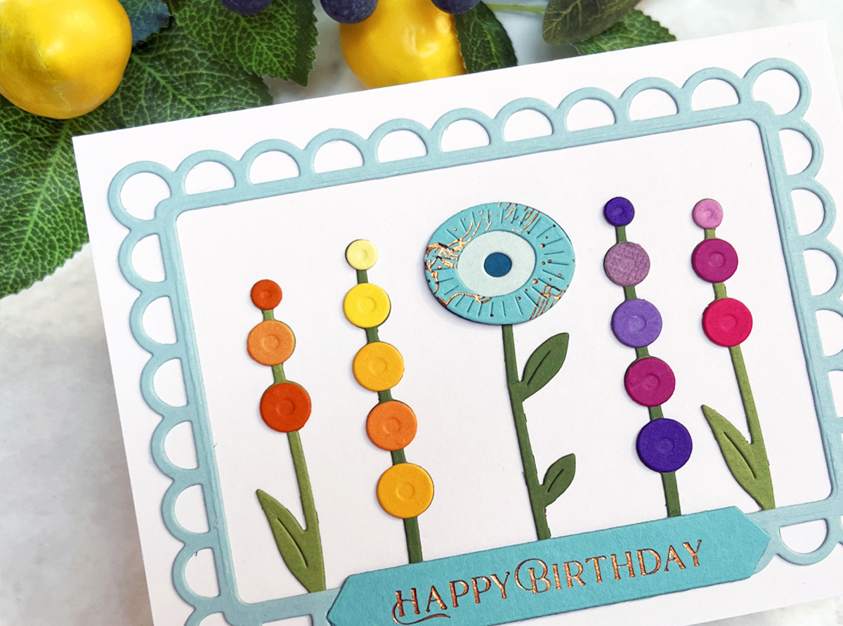 Close-up photo of  rainbow colored circle die cut floral elements on a birthday card
