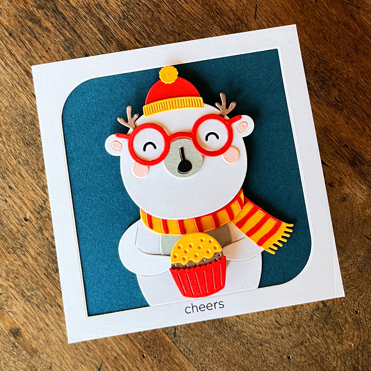 Interactive Christmas card with a white polar bear holding a spinning cupcake on an Oceanside blue background.