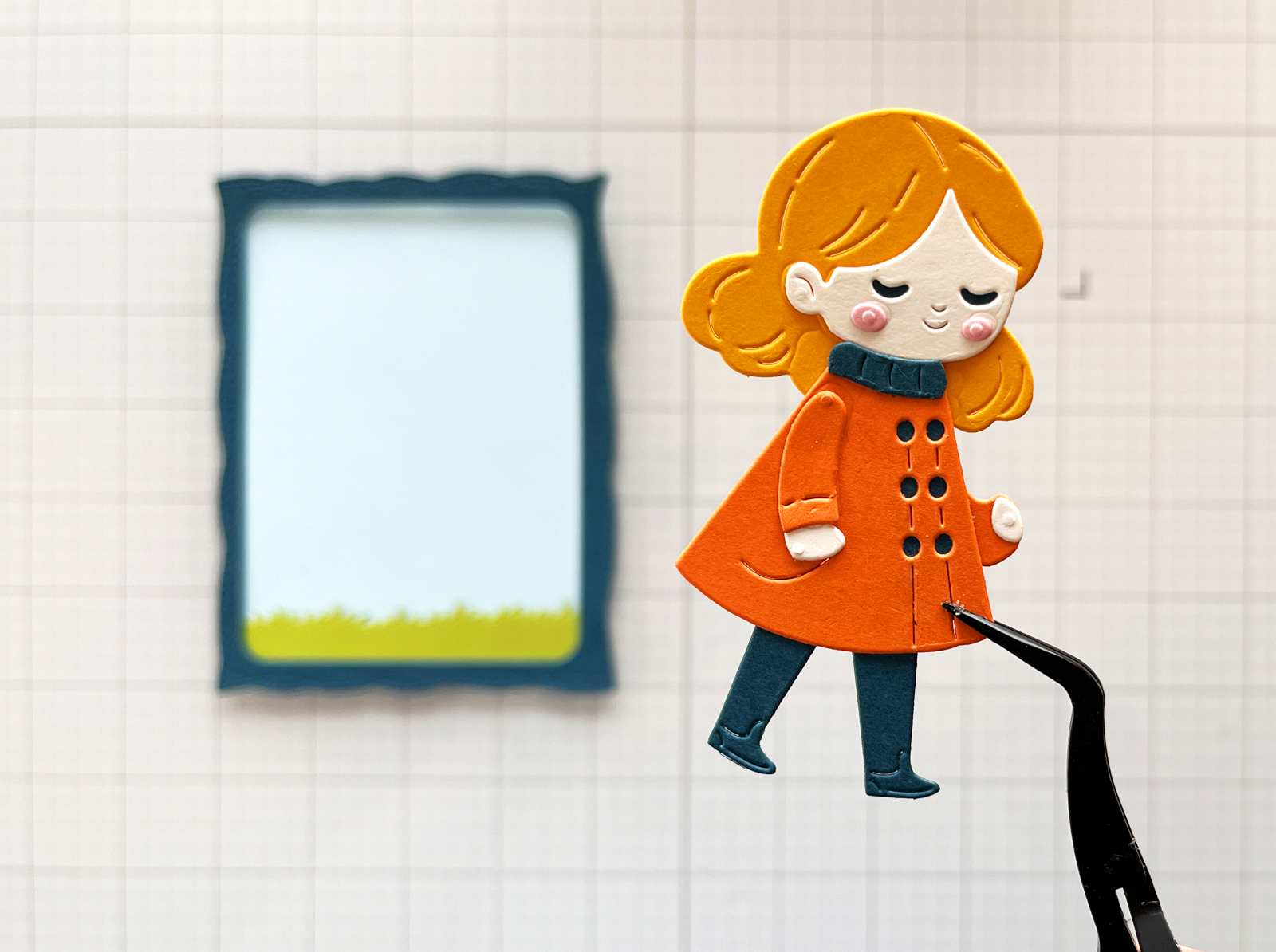 Die cut girl in an orange coat ready to add to a handmade scene card