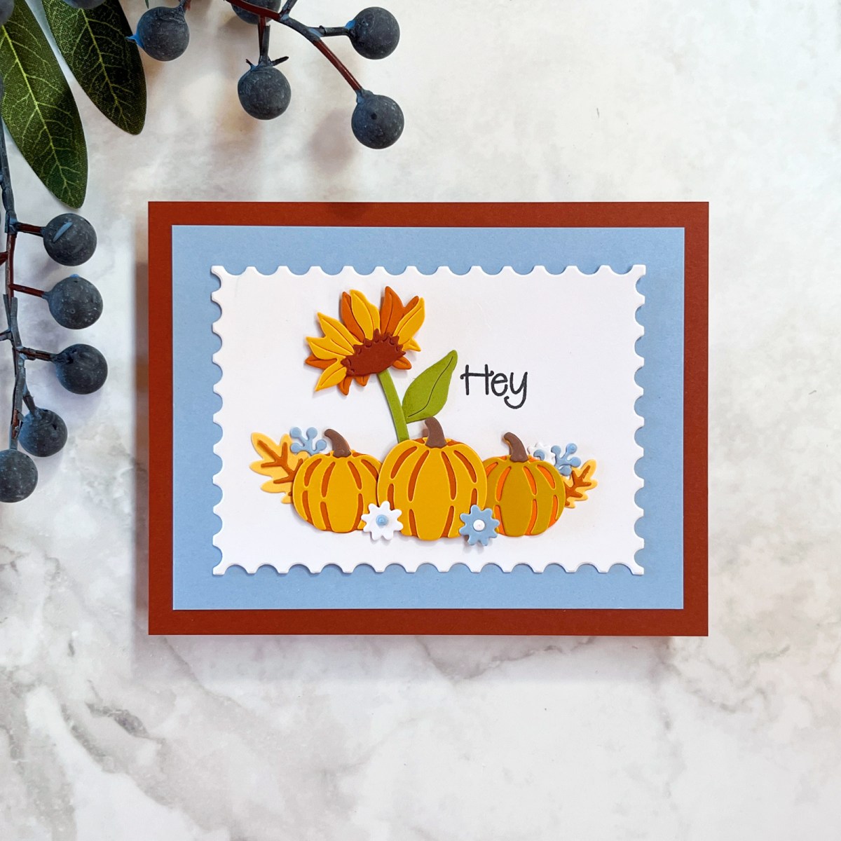 Cheery die-cut pumpkin and sunflower card with layered background.  Colors used are blue-grey, rust, orange and yellow. 